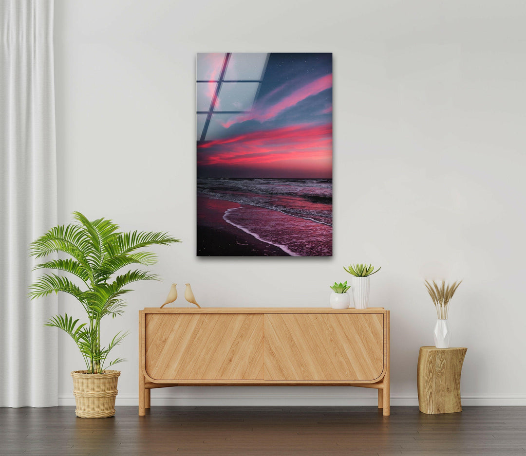Modern glass art print with a dramatic sunset over a dark sandy beach.
