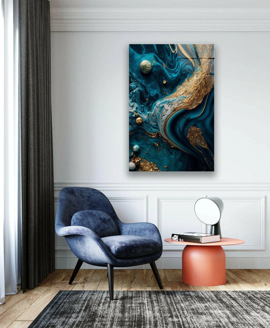 A blue velvet armchair and a coral side table with a lamp and book in the foreground against a modern abstract glass art painting.