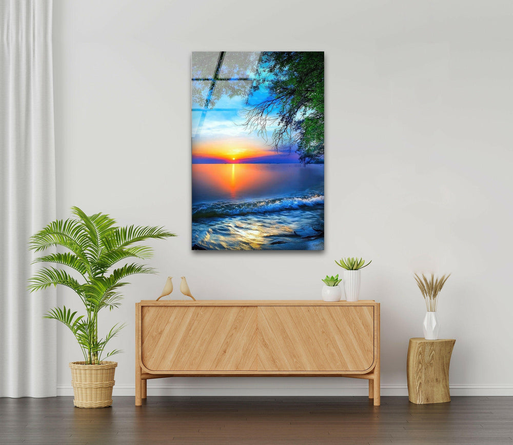 Serene seascape featuring gentle waves, a glowing sunset, and lush greenery on glass.
