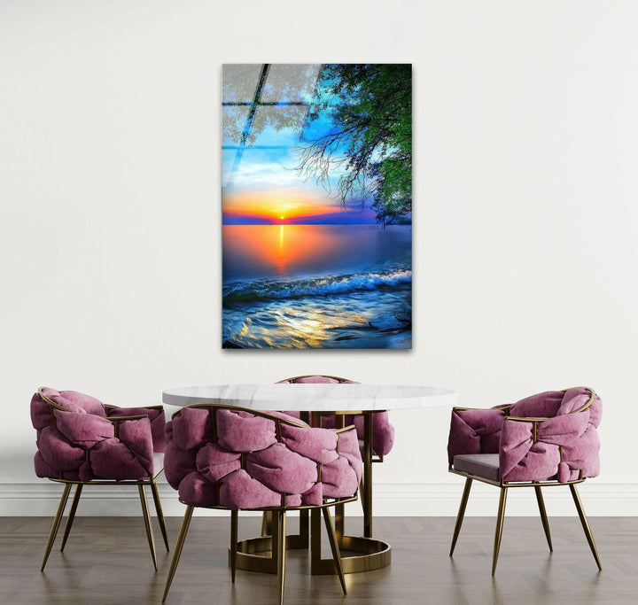 Modern glass wall art featuring a dreamy sunset over a still ocean and soft beach waves.
