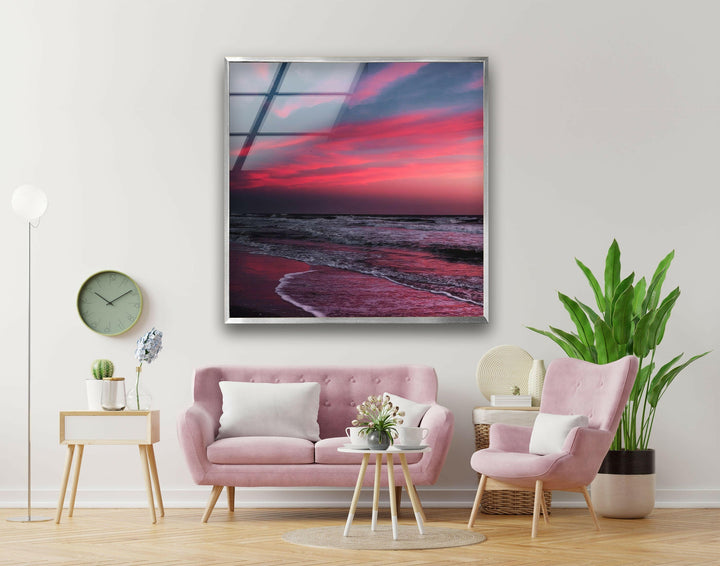 Coastal artwork with soft ocean waves and a glowing red and purple sunset.
