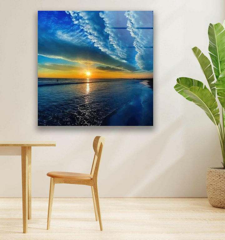 High-definition glass wall art showcasing a mesmerizing sky over the ocean at sunset.
