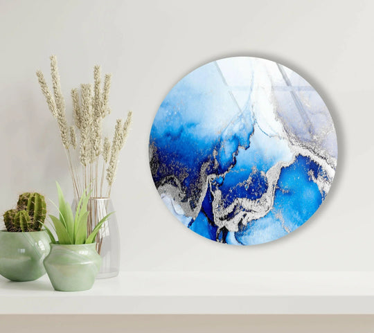 The darkest area highlights the dramatic contrast within the blue marble round glass wall art prints, accented by shimmering silver details.