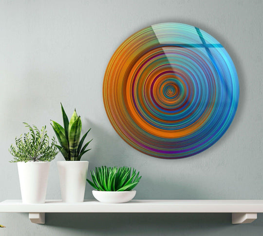 Striking color contrast defines the round glass wall art, where orange and blue hues swirl in a captivating spiral, enhancing its home decor appeal.