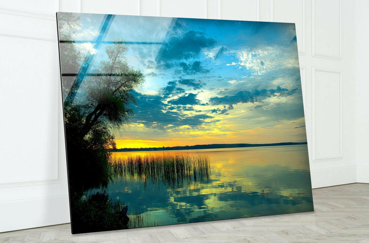 Breathtaking landscape featuring a peaceful lake, golden sunset, and soft clouds.
