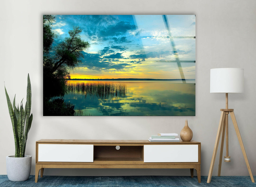 Tranquil nature-inspired glass wall art showcasing a golden sky over a still lake.
