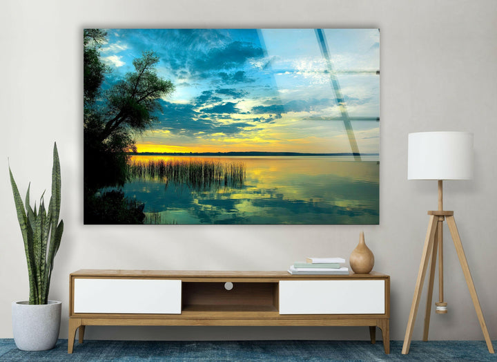 Tranquil nature-inspired glass wall art showcasing a golden sky over a still lake.
