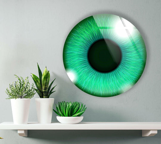 Light and shadow accentuate the vivid green eye in this art from glass, emphasizing its depth and glossy surface on the round glass wall art.
