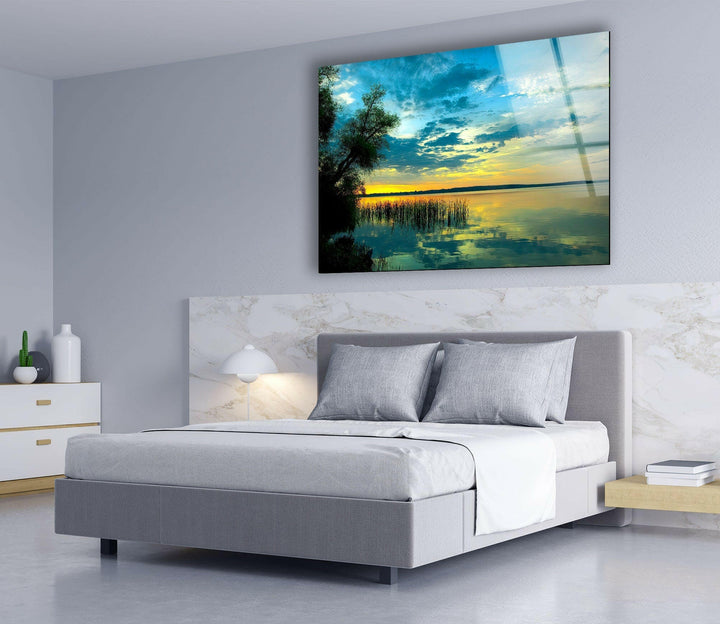 Luxury glass wall art displaying a golden sunset over a serene lakeside view.
