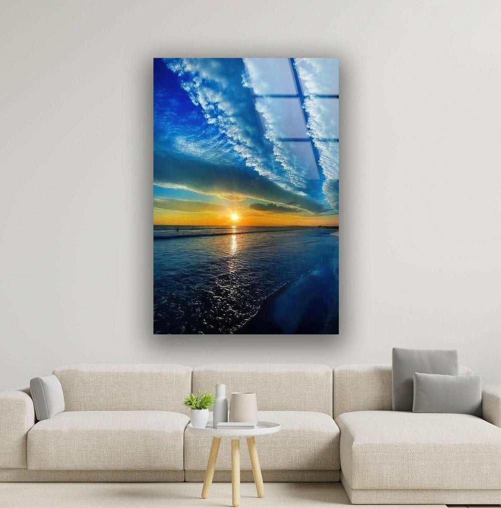 Breathtaking beach sunset reflecting on the water with deep blue and golden hues.
