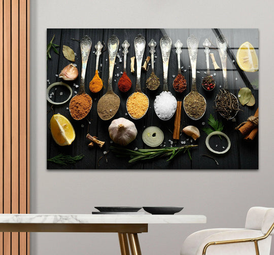 Horizontal glass wall art displaying ornate silver spoons filled with colorful spices and fresh ingredients above a dining table for rustic kitchen decor.