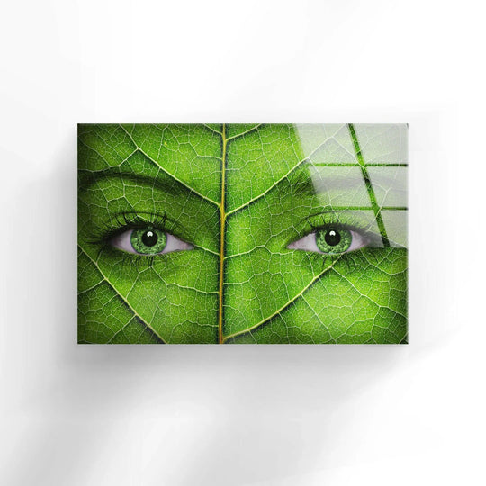 A woman's face transitions from vibrant green leaf texture to subtle skin tones in this tempered glass wall art.