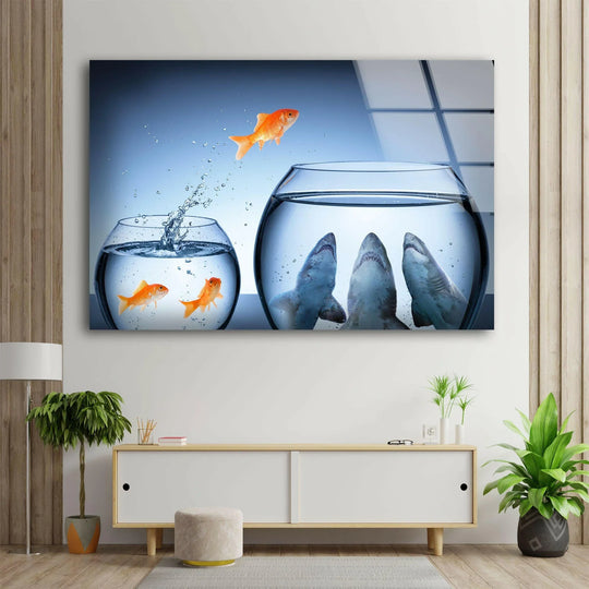 Goldfish Shark glass wall art depicting a brave goldfish leaping from a smaller bowl to a larger one filled with sharks, perfect for home decor.