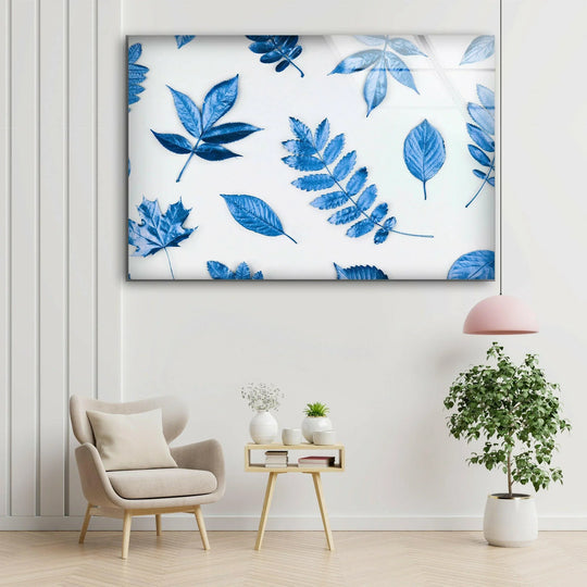 Visual rhythm is created by the scattered blue leaves on the white background of this striking Blue Leaves, best glass art wall decor.