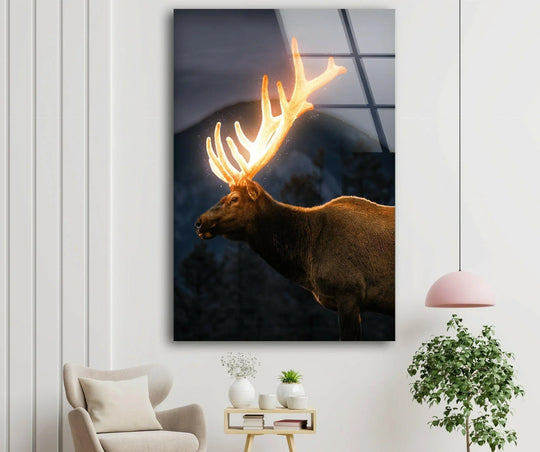 A majestic elk with glowing antlers stands in quiet stillness as art from glass.