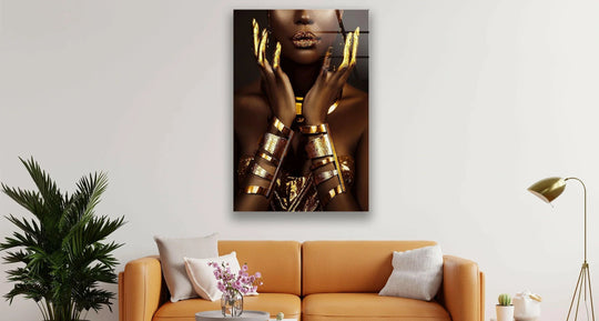 This glass printing showcases a woman adorned in opulent gold jewelry, revealing layers of shimmer and rich texture.
