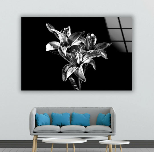 Monochrome artwork featuring three detailed lilies against a deep black background.