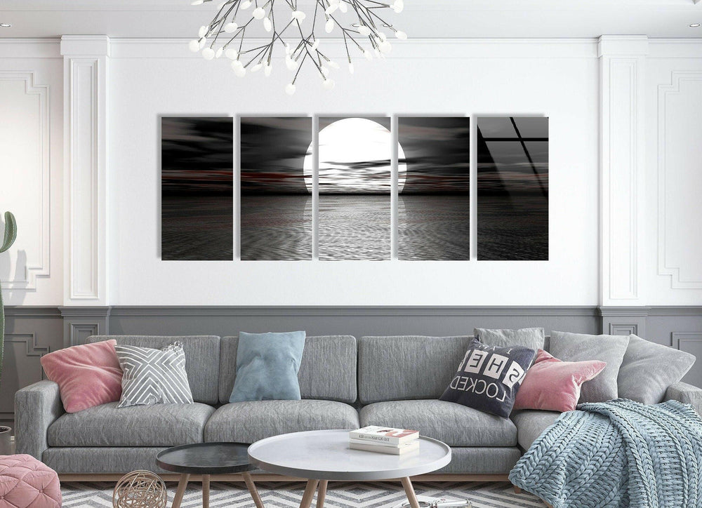 Dramatic black and white glass wall art featuring a large glowing moon rising over rippling water.