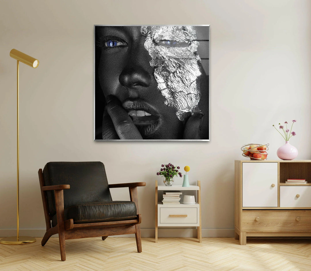 Bold glass wall art depicting a metallic-inspired face with dramatic blue eye highlights.