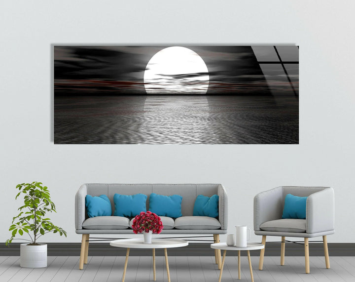 Modern glass wall art of a dramatic moonrise above a rippled sea.