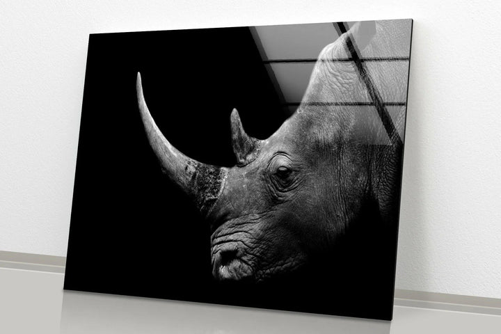 Monochrome glass artwork showing a detailed rhino head with prominent horn in dramatic contrast.